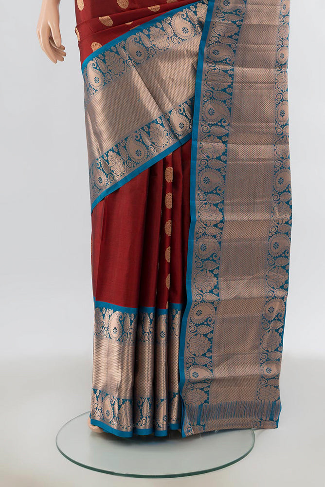 Pleats and pallu of Maroon Kanchipuram Silk Saree with Zari Butta on the body and Silk Border. 