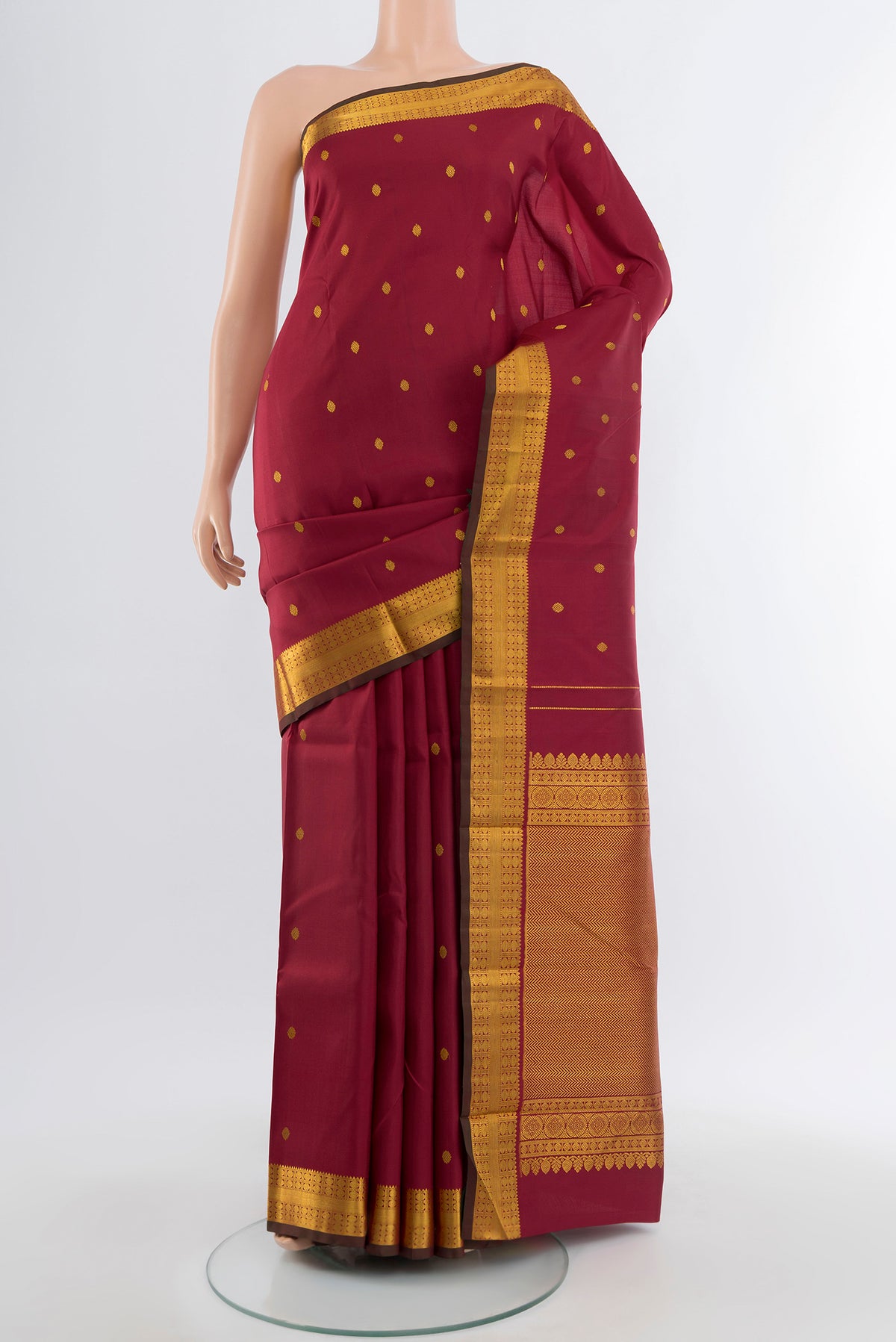 Maroon Kanchipuram Silk Saree with Zari Butta on the body and Silk Border.  displayed on a mannequin