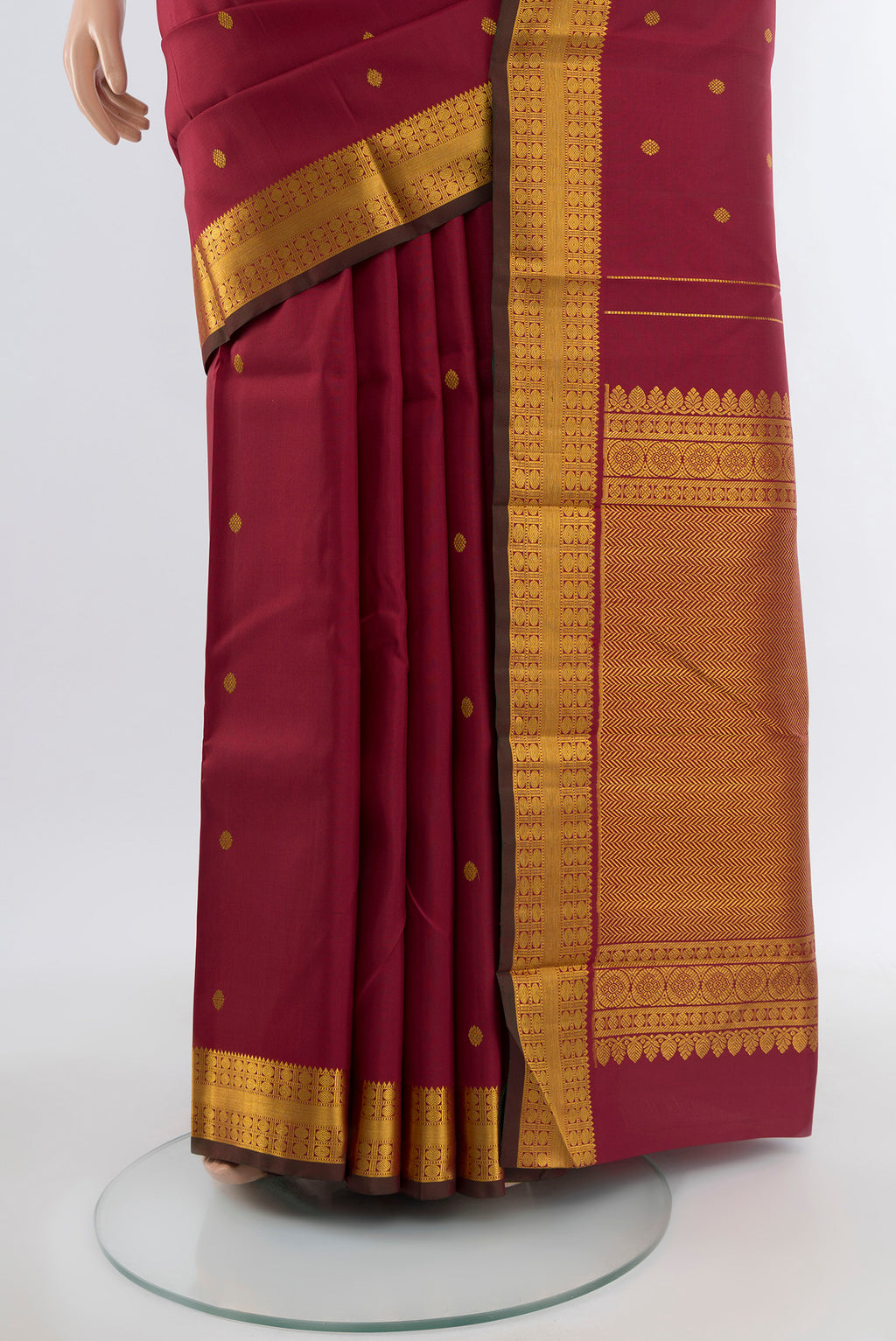 Pleats and pallu of Maroon Kanchipuram Silk Saree with Zari Butta on the body and Silk Border. 