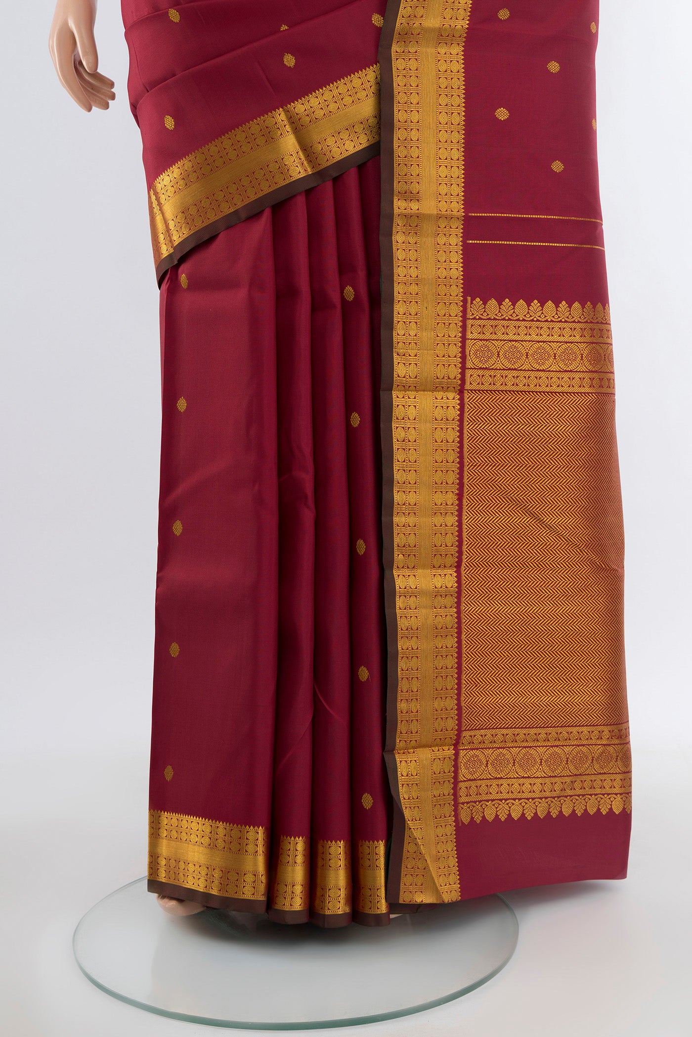 Pleats and pallu of Maroon Kanchipuram Silk Saree with Zari Butta on the body and Silk Border. 