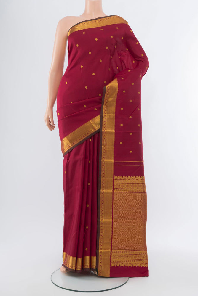 Maroon Kanchipuram Silk Saree with Zari Butta on the body and Silk Border.  displayed on a mannequin