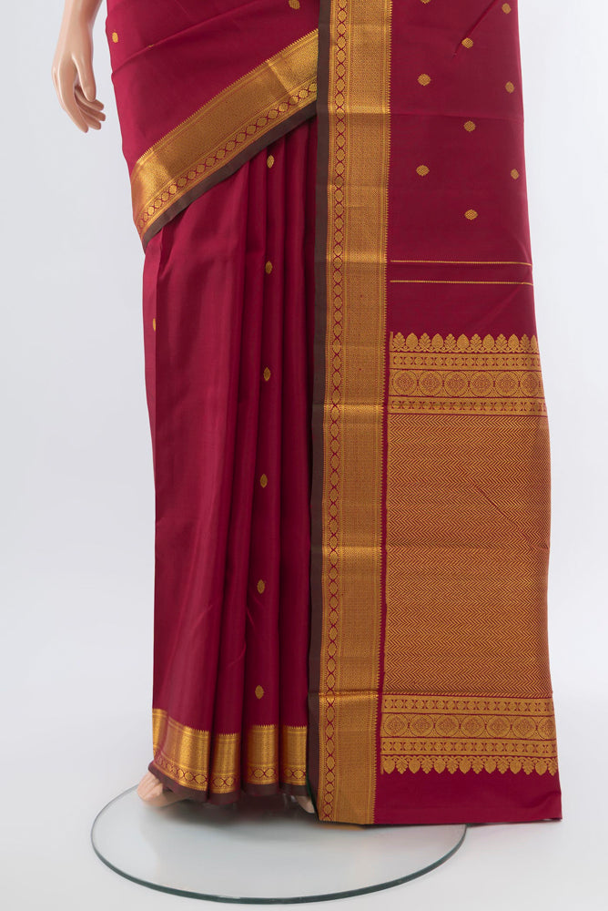 Pleats and pallu of Maroon Kanchipuram Silk Saree with Zari Butta on the body and Silk Border. 