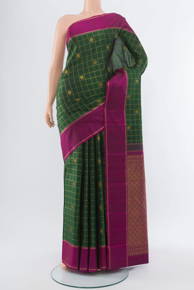 Bottle Green Kanchipuram Silk Saree with Zari Butta on the body and Silk Border.  displayed on a mannequin