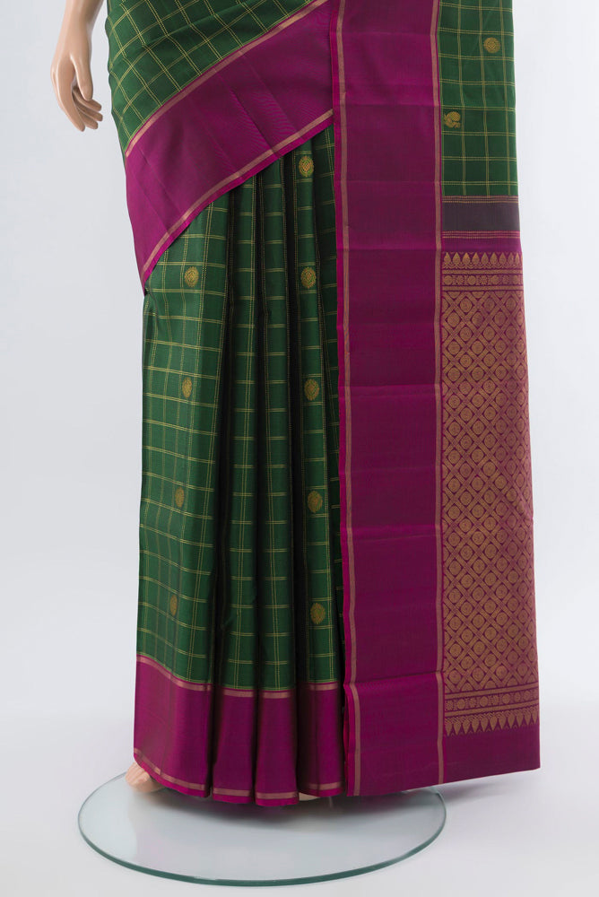 Pleats and pallu of Bottle Green Kanchipuram Silk Saree with Zari Butta on the body and Silk Border. 