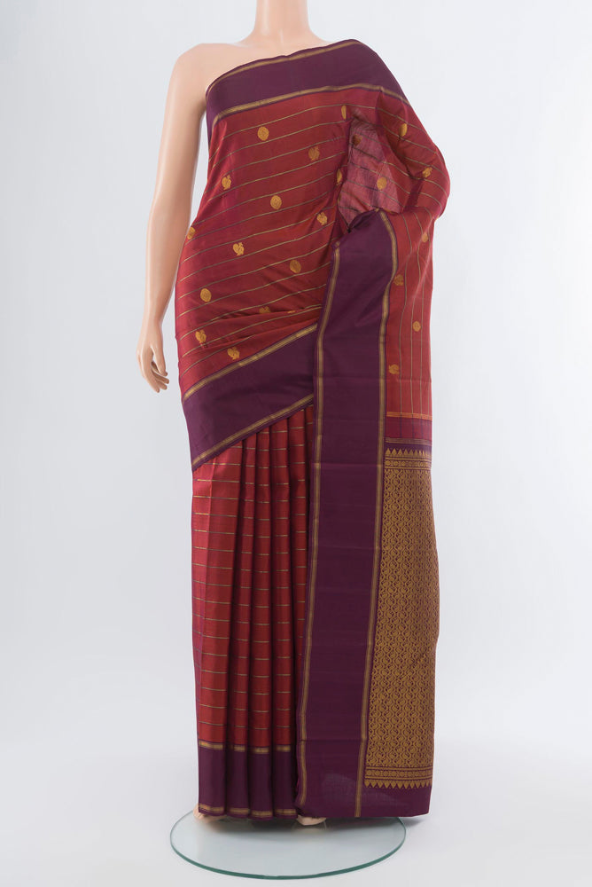 Maroon Kanchipuram Silk Saree with Zari Butta on the body and Silk Border.  displayed on a mannequin