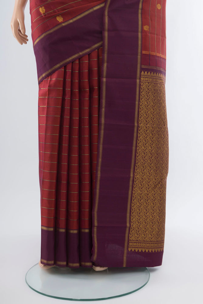 Pleats and pallu of Maroon Kanchipuram Silk Saree with Zari Butta on the body and Silk Border. 