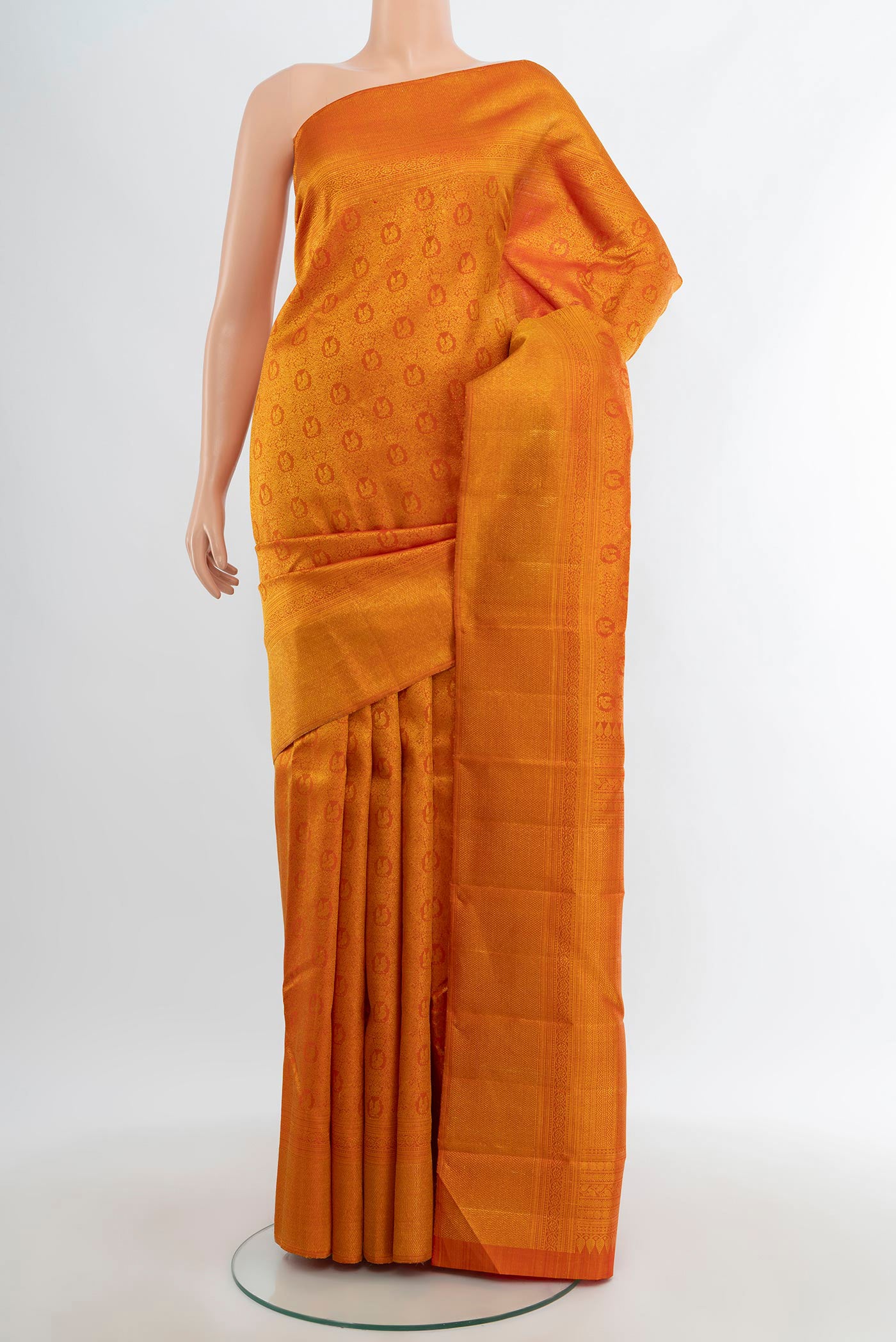 Brick Orange Kanchipuram Silk Saree with Zari Brocade on the body and Zari Border.  displayed on a mannequin