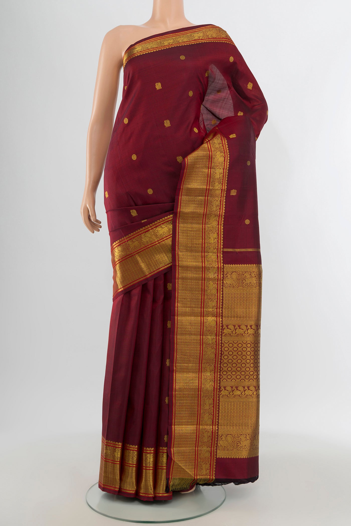 Pure Silk Pure Zari Maroon Kanchipuram Saree with Zari Butta on the body and Zari Border.  displayed on a mannequin