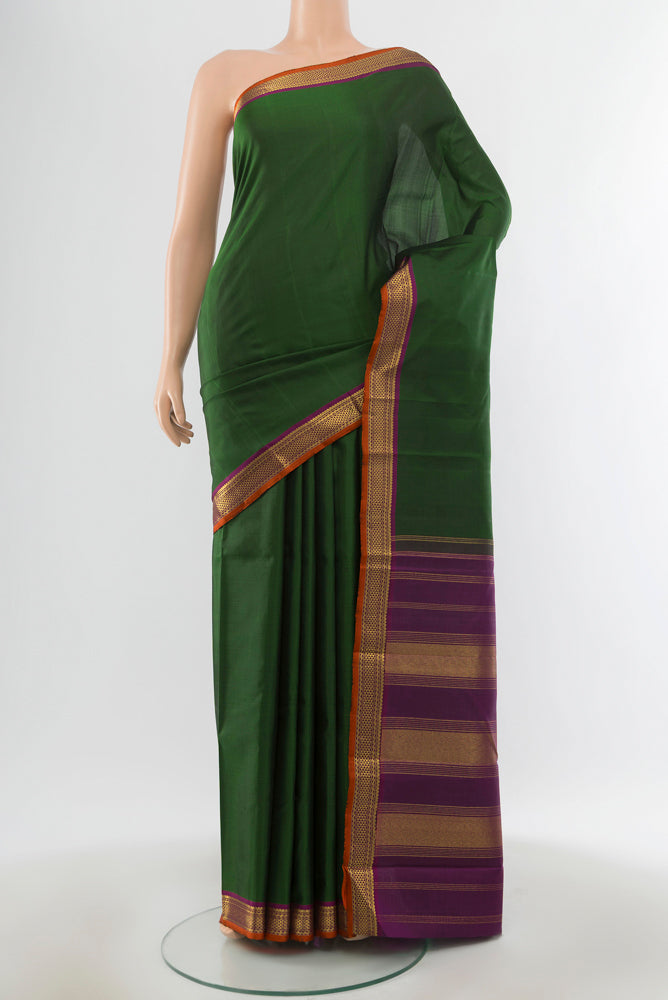 Pure Silk Pure Zari Bottle Green Kanjivaram Saree with Zari Butta on the body and Silk Border.  displayed on a mannequin