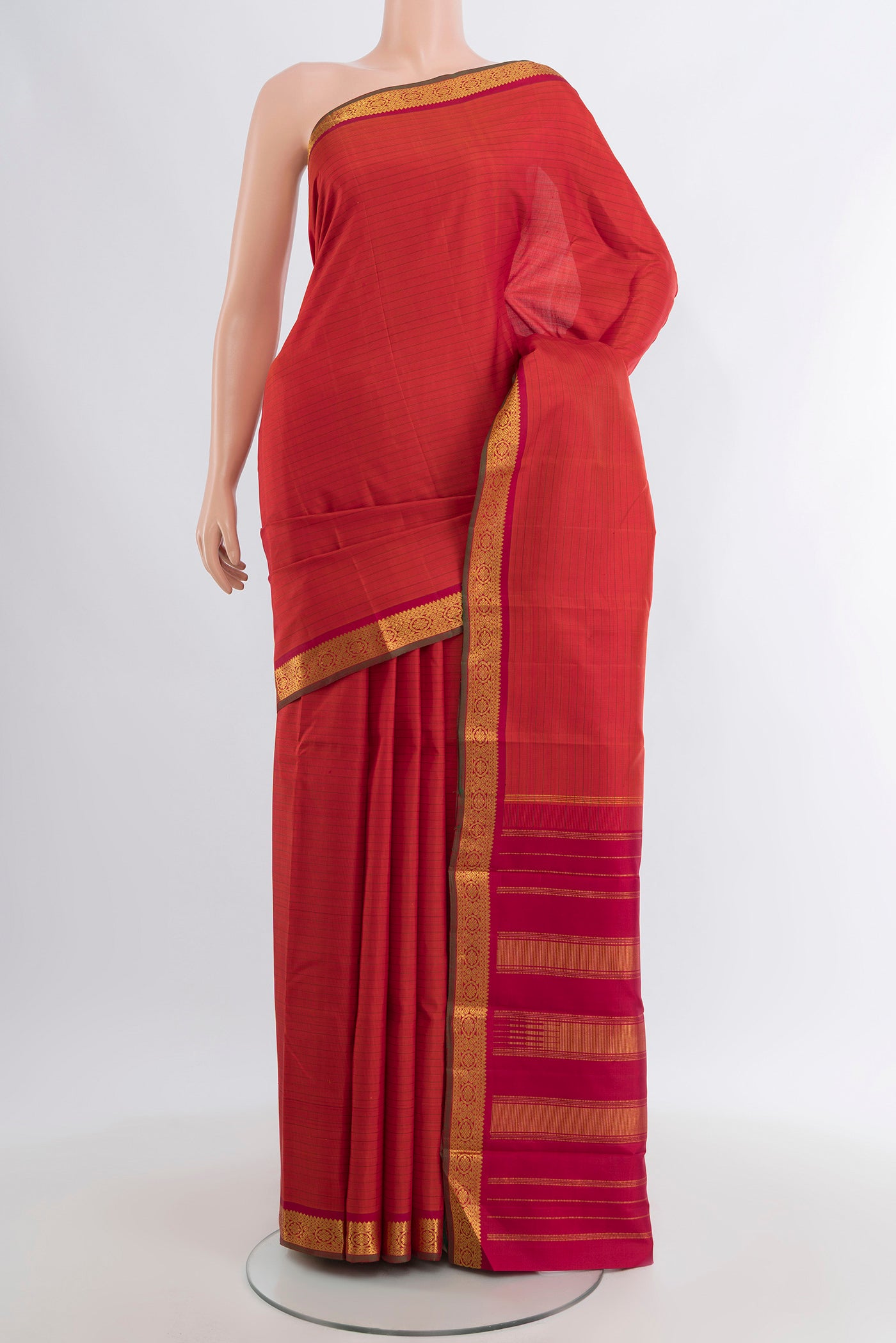 Brick Orange Kanchipuram Silk Saree with Stripes on the body and Zari Border.  displayed on a mannequin