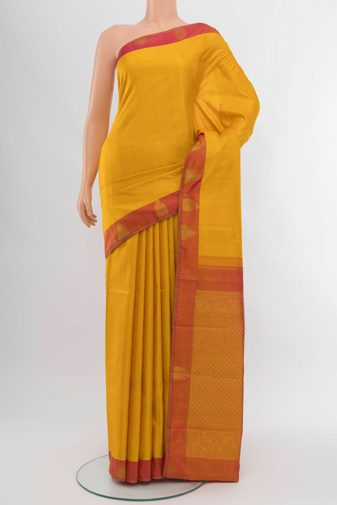 Mustard Kanjivaram Silk Saree with Zari Brocade on the body and Silk Border.  displayed on a mannequin