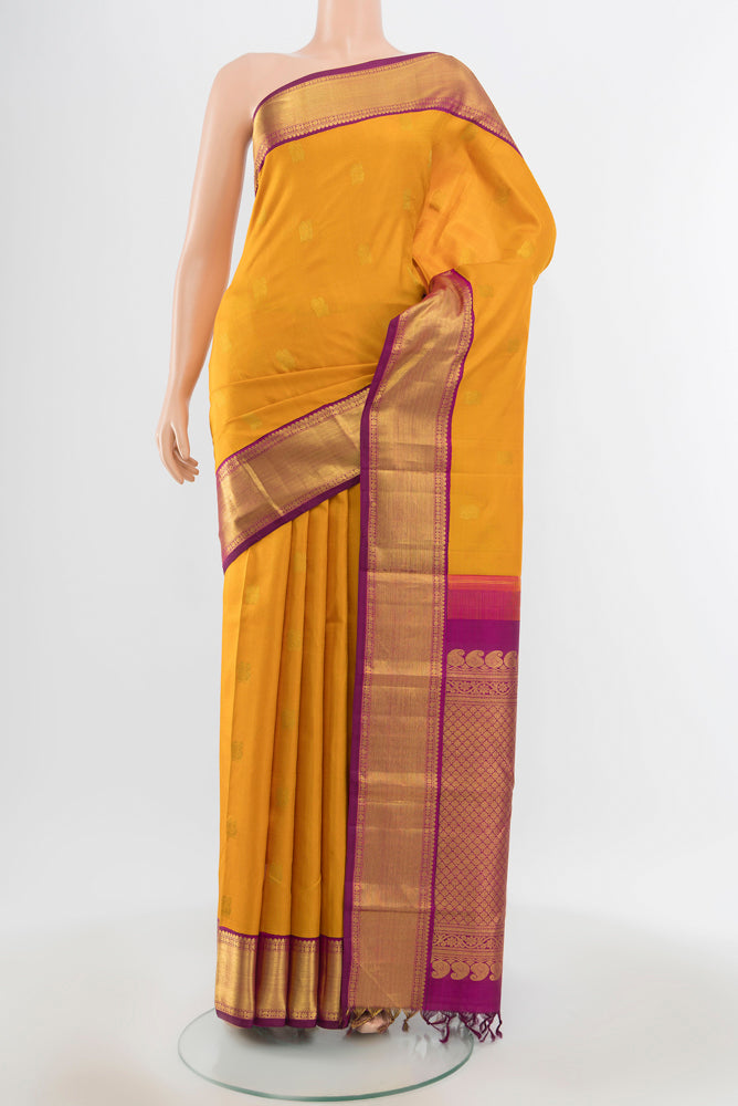 Pure Silk Pure Zari Mustard Kanjivaram Saree with Zari Butta on the body and Silk Border.  displayed on a mannequin