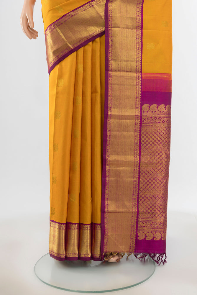 Pleats and pallu of Pure Silk Pure Zari Mustard Kanjivaram Saree with Zari Butta on the body and Silk Border. 