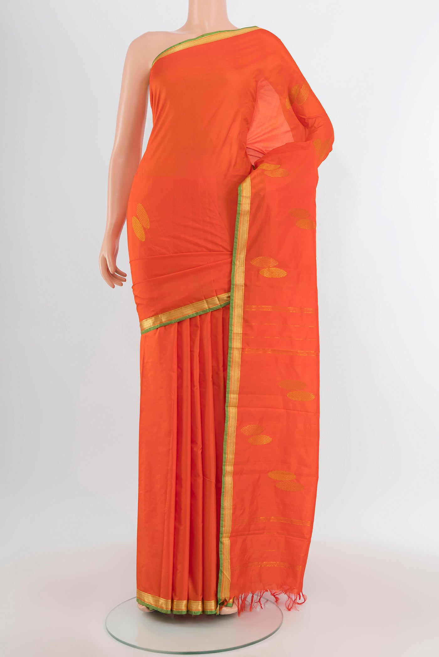 Orange Kanjivaram Silk Saree with Thread Butta on the body and Zari Border.  displayed on a mannequin
