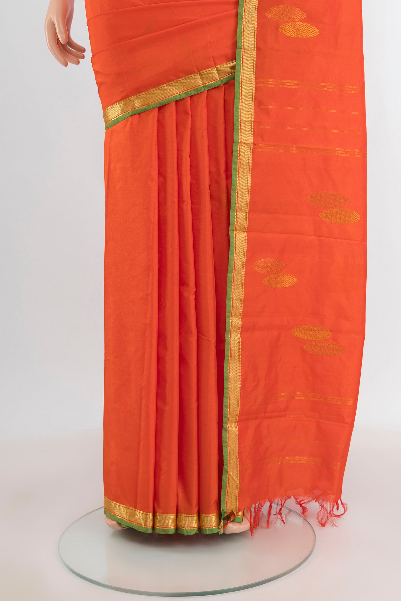 Pleats and pallu of Orange Kanjivaram Silk Saree with Thread Butta on the body and Zari Border. 