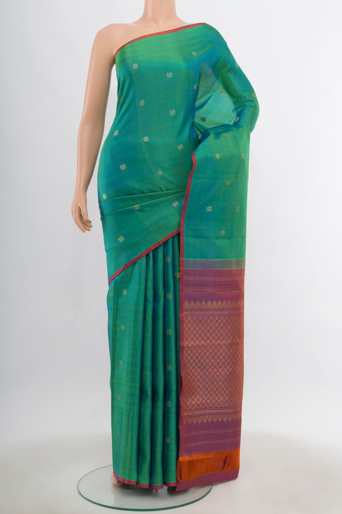Peacock Blue Kanchipuram Silk Saree with Zari Butta on the body and Silk Border.  displayed on a mannequin
