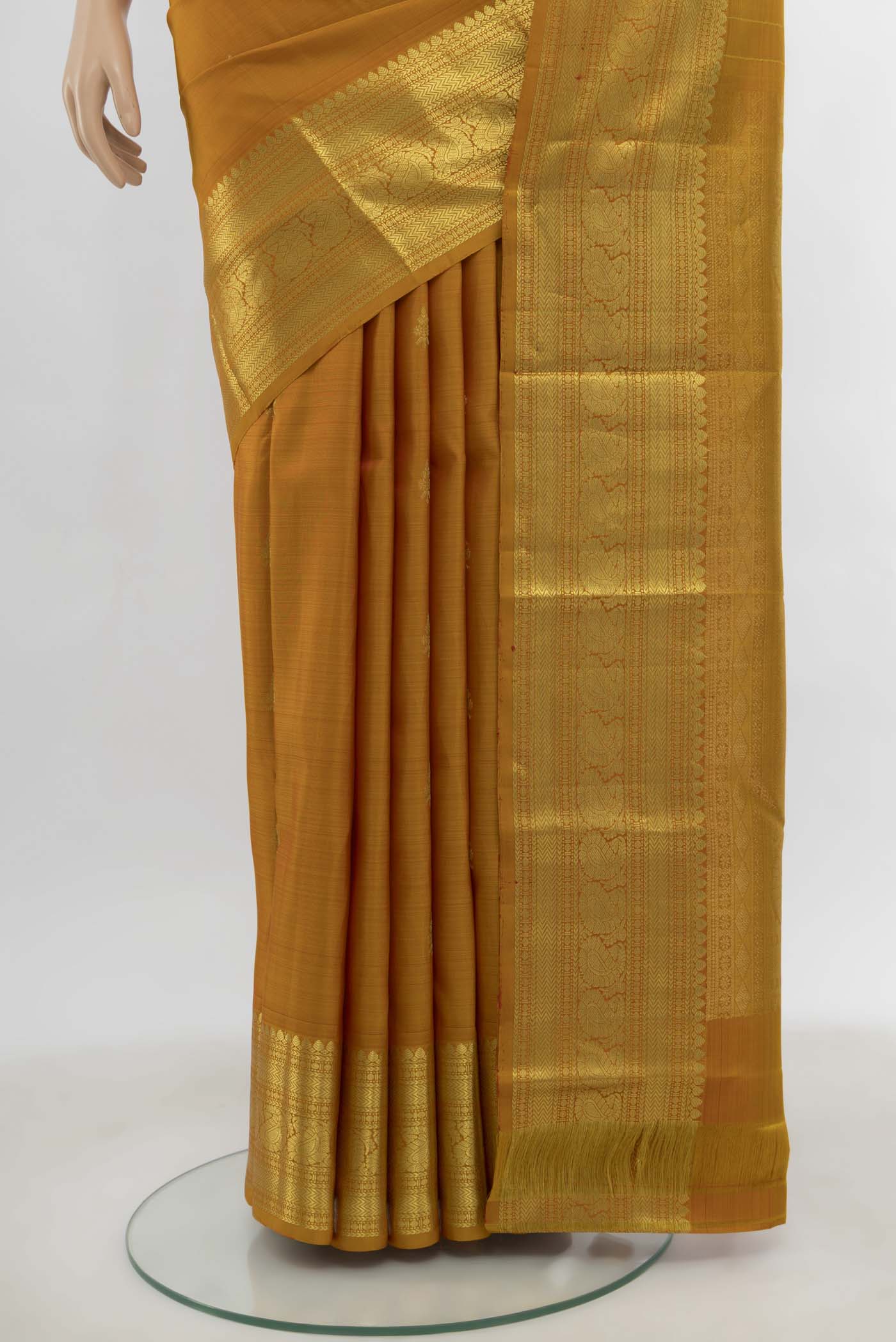 Pleats and pallu of Mustard Kanchipuram Silk Saree with Zari Butta on the body and Silk Border. 