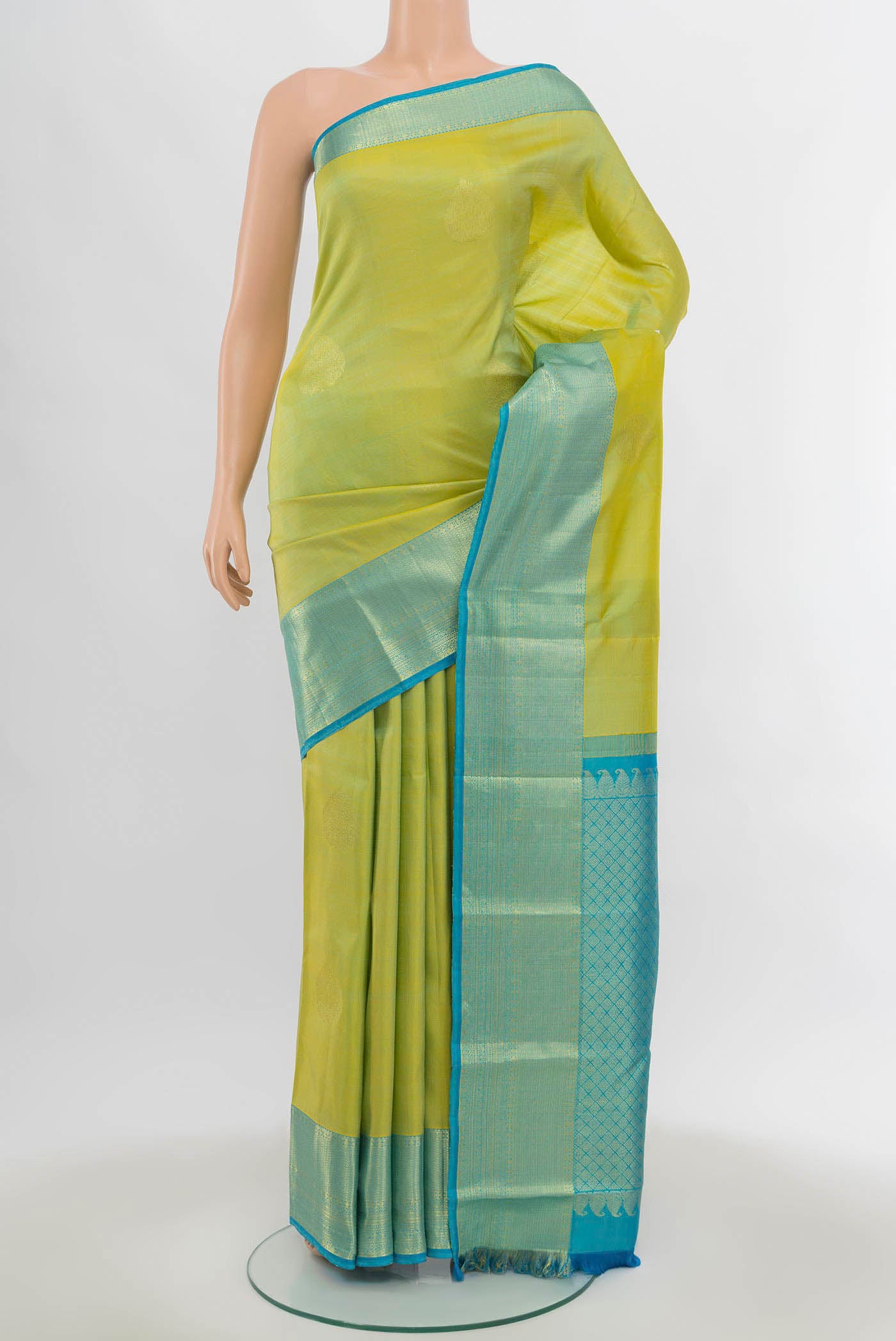 Light Green Kanchipuram Silk Saree with Zari Butta on the body and Silk Border.  displayed on a mannequin