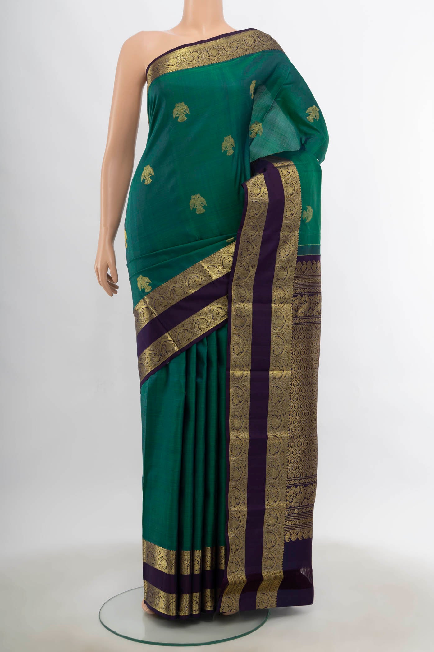 Peacock Blue Kanchipuram Silk Saree with Zari Butta on the body and Silk Border.  displayed on a mannequin