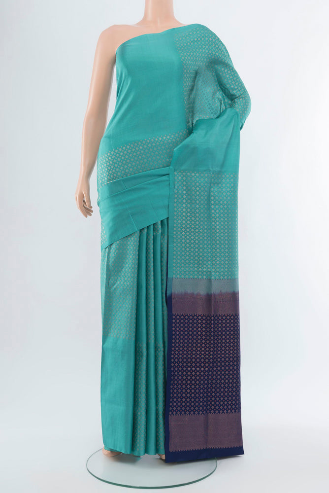 Light Blue Soft Silk Saree with Zari Butta on the body and Silk Border.  displayed on a mannequin