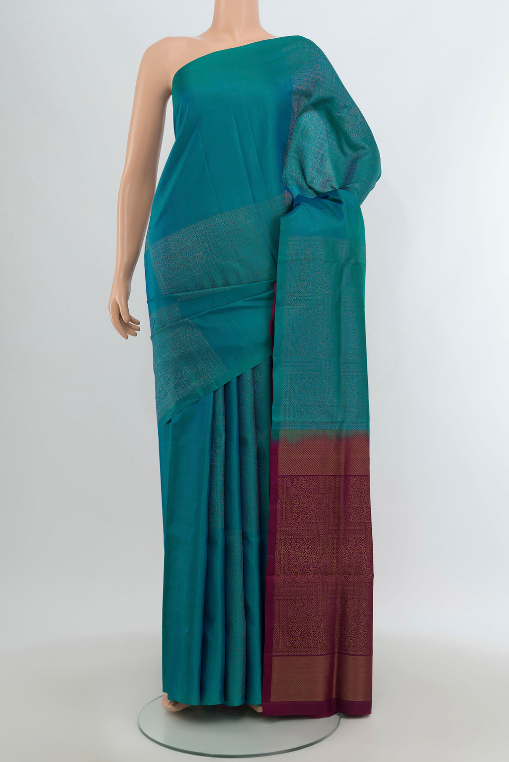 Peacock Blue Soft Silk Saree with Plain Body and Without Border.  displayed on a mannequin