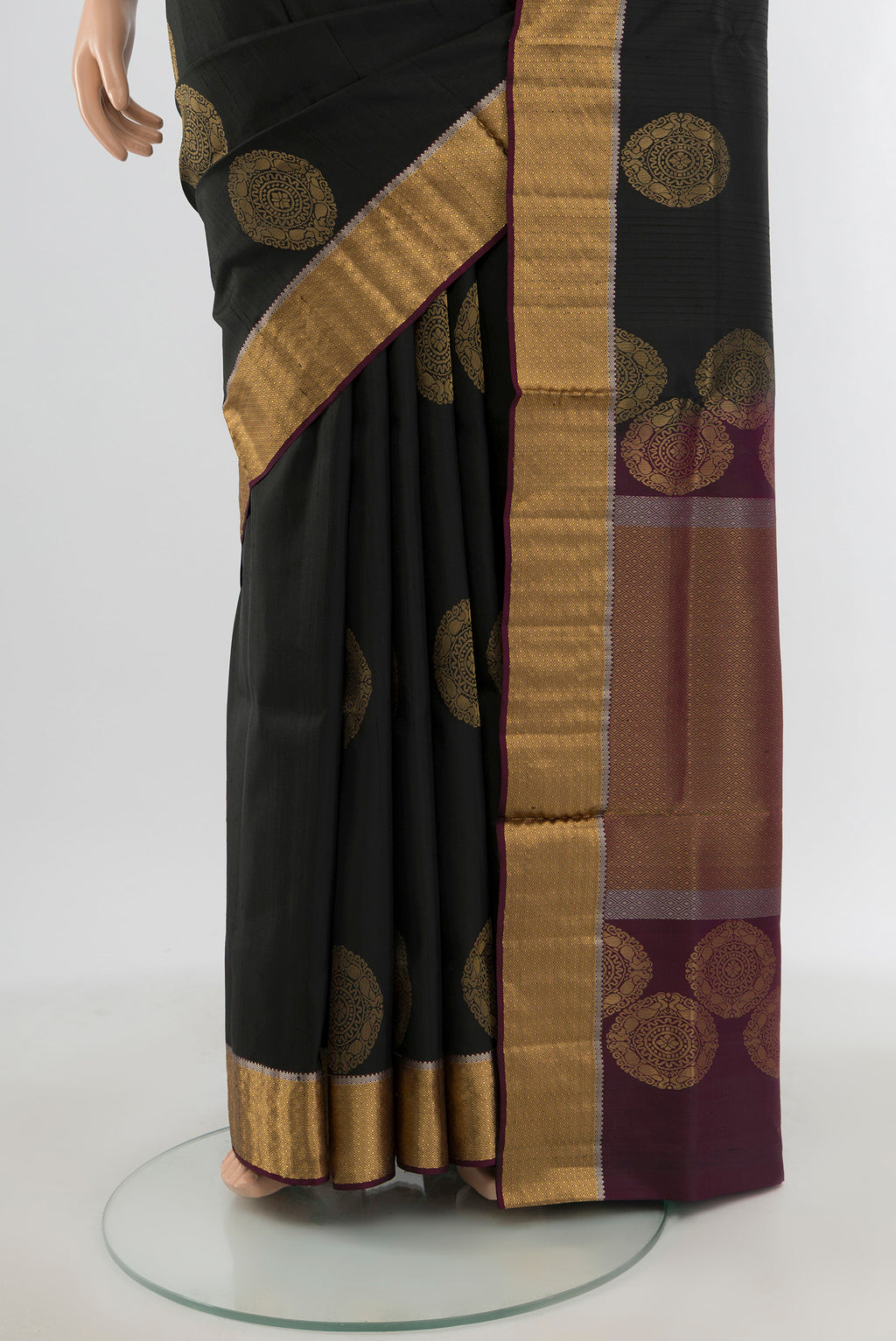 Pleats and pallu of Black Soft Silk Saree with Zari Butta on the body and Zari Border. 