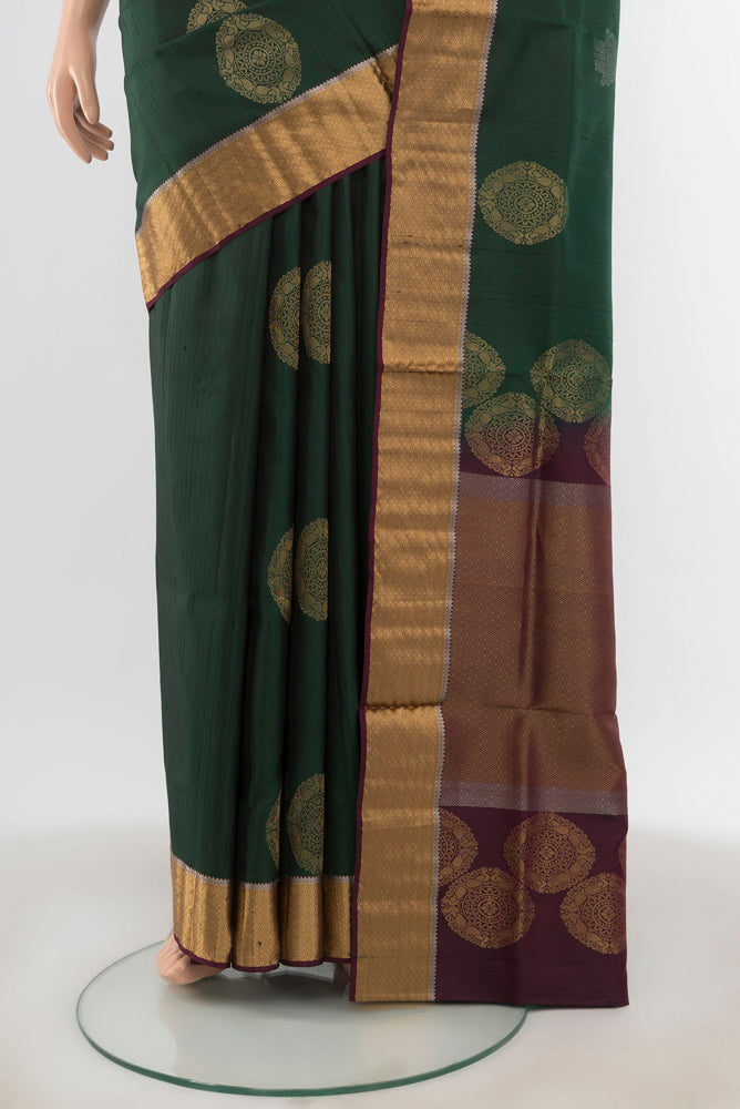 Pleats and pallu of Bottle Green Soft Silk Saree with Zari Butta on the body and Silk Border. 