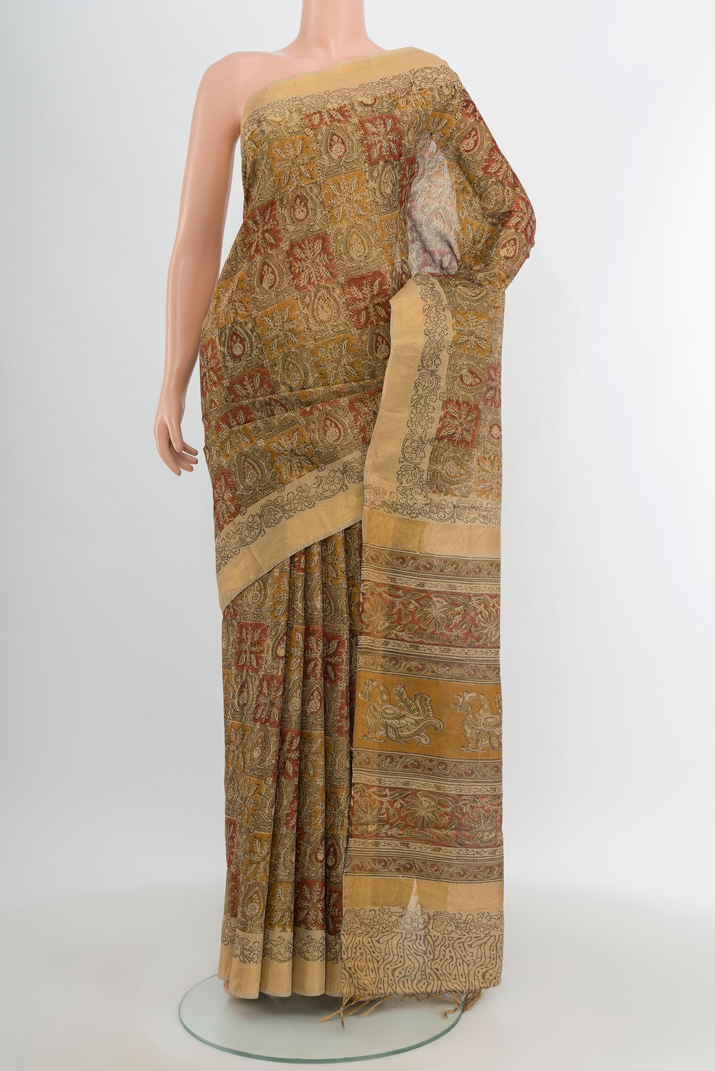 Beige Tussar Silk Saree with kalamkari Print on the body and Zari Border.  displayed on a mannequin