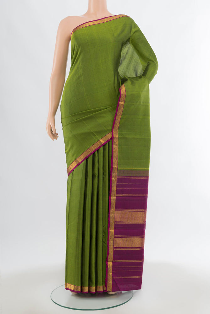 Green Kanjivaram Silk Saree with Zari Butta on the body and Silk Border.  displayed on a mannequin