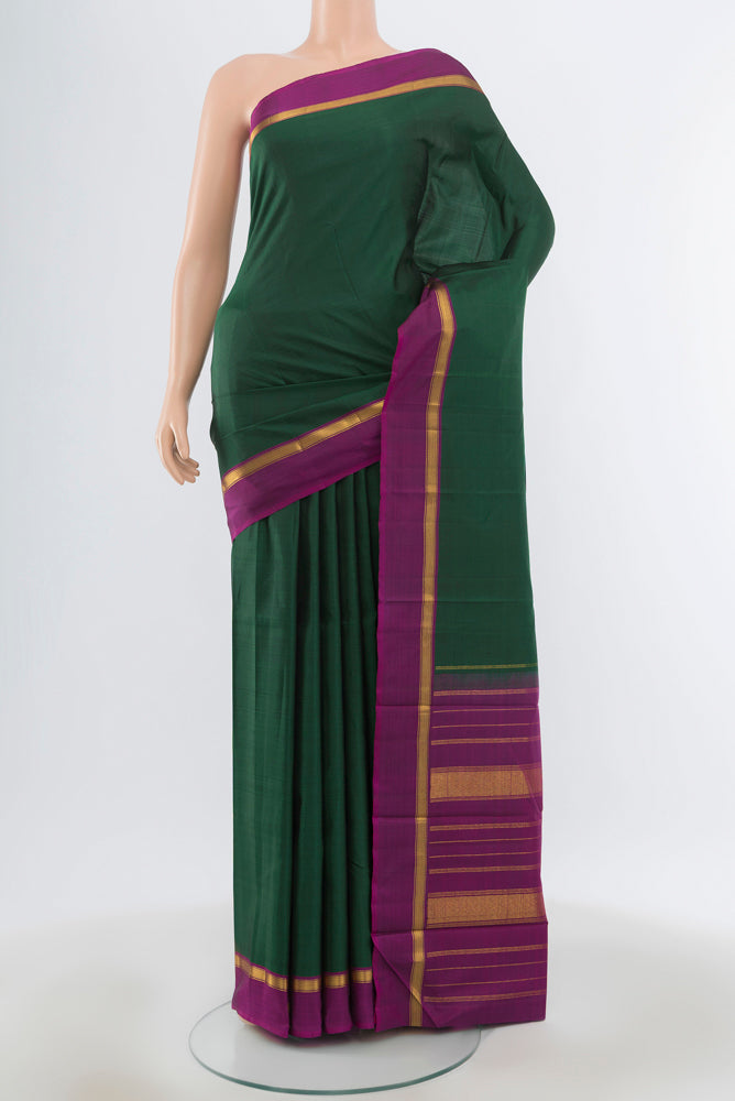 Mint Green Kanjivaram Silk Saree with Plain Body and Silk Border.  displayed on a mannequin