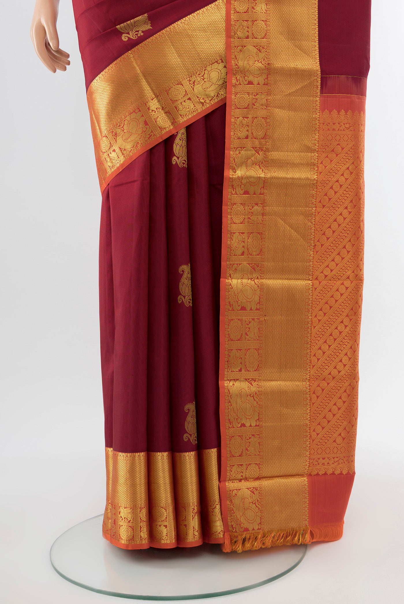 Pleats and pallu of Maroon Kanchipuram Silk Saree with Zari Butta on the body and Silk Border. 