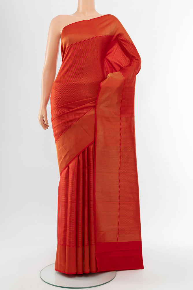 Rust Kanchipuram Silk Saree with Zari Butta on the body and Silk Border.  displayed on a mannequin