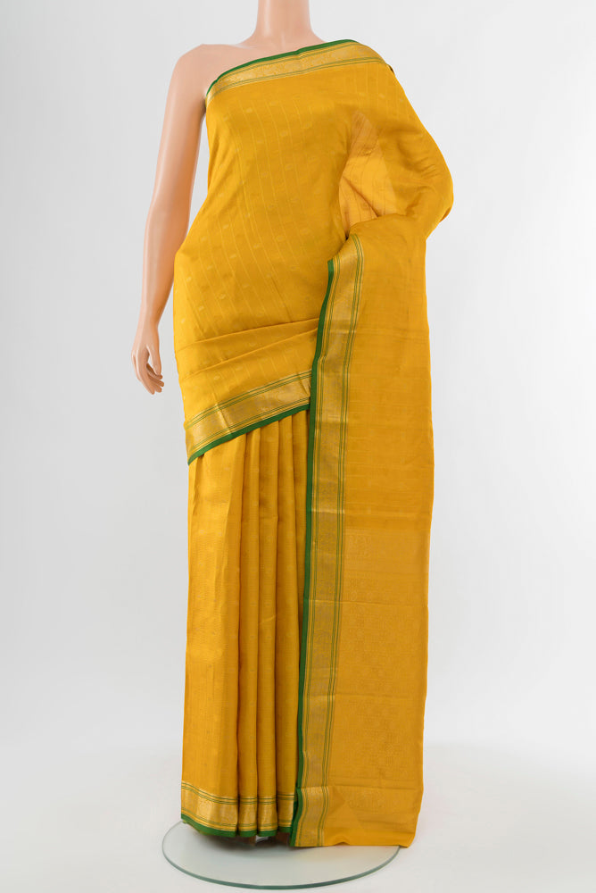 Yellow Kanchipuram Silk Saree with Zari Butta on the body and Silk Border.  displayed on a mannequin