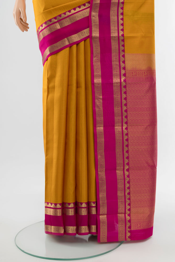 Pleats and pallu of Mustard Kanchipuram Silk Saree with Zari Butta on the body and Silk Border. 