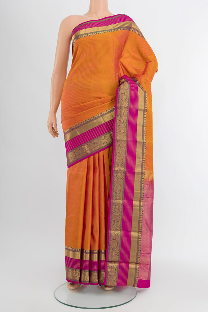 Golden Peach Kanjivaram Silk Saree with Zari Butta on the body and Silk Border.  displayed on a mannequin