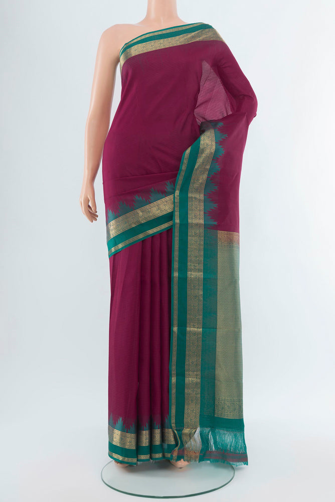 Maroon Kanchipuram Silk Saree with Zari Butta on the body and Silk Border.  displayed on a mannequin
