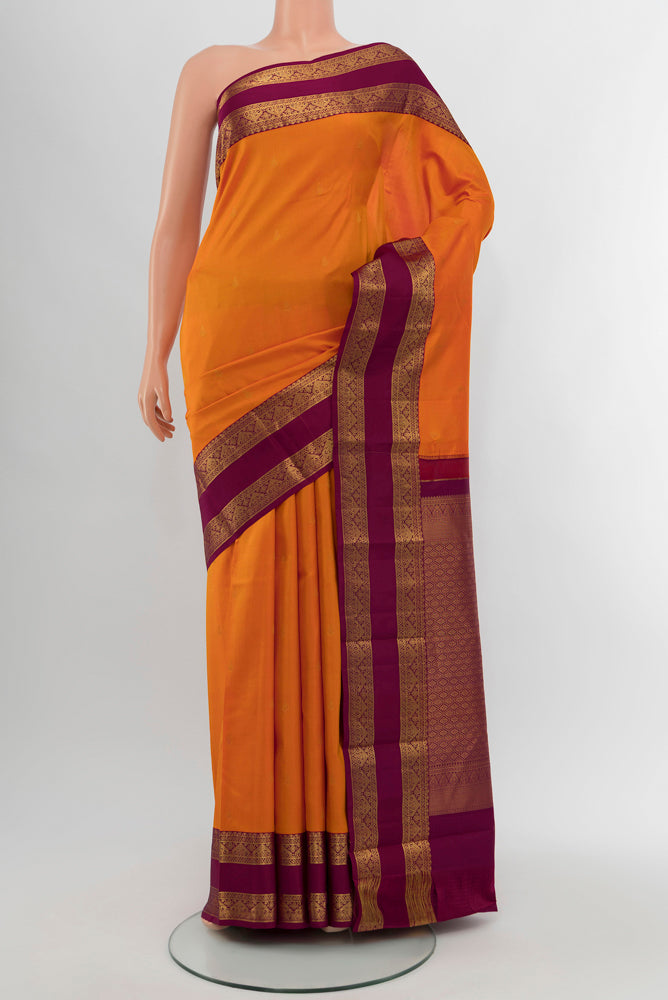 Orange Kanchipuram Silk Saree with Zari Butta on the body and Silk Border.  displayed on a mannequin