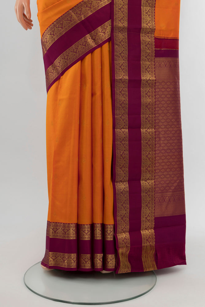 Pleats and pallu of Orange Kanchipuram Silk Saree with Zari Butta on the body and Silk Border. 