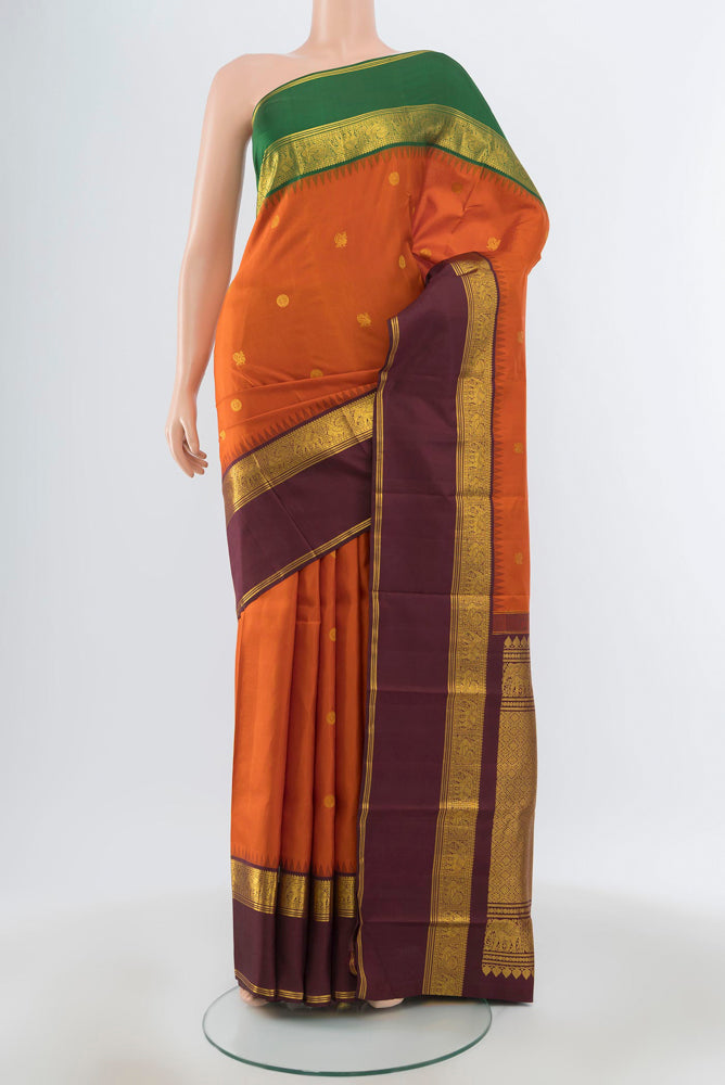 Pure Silk Pure Zari Rust Kanjivaram Saree with Zari Butta on the body and Silk Border.  displayed on a mannequin