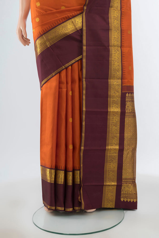 Pleats and pallu of Pure Silk Pure Zari Rust Kanjivaram Saree with Zari Butta on the body and Silk Border. 
