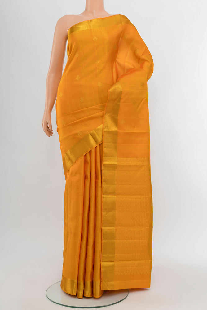Mustard Kanjivaram Silk Saree with Zari Butta on the body and Silk Border.  displayed on a mannequin