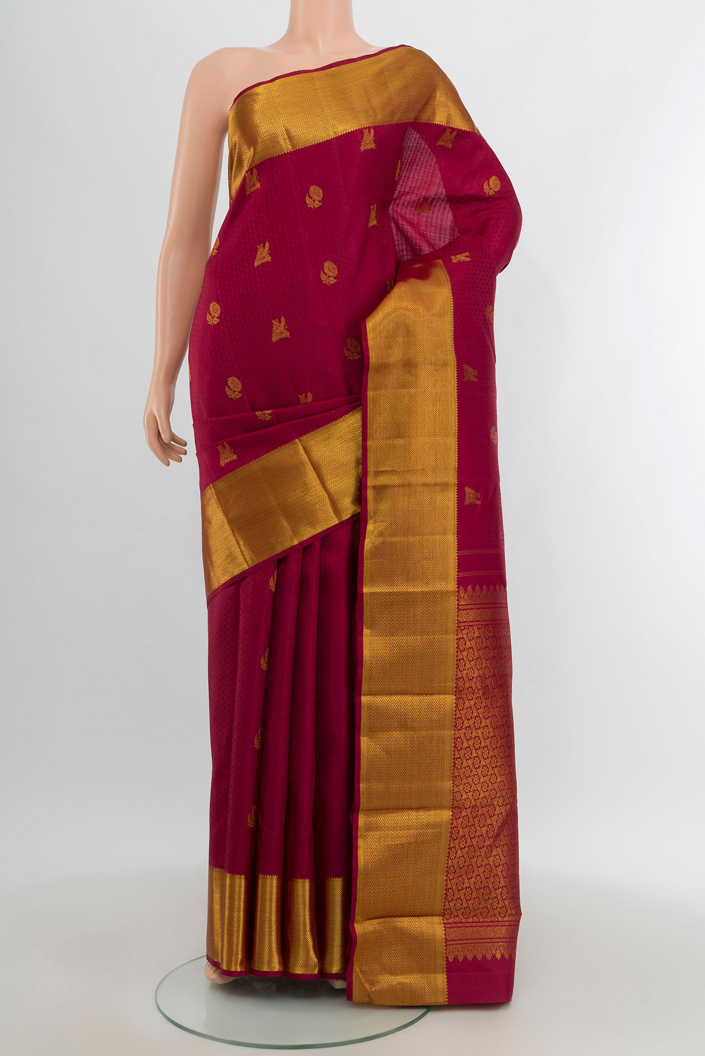 Maroon Kanjivaram Silk Saree with Zari Butta on the body and Zari Border.  displayed on a mannequin