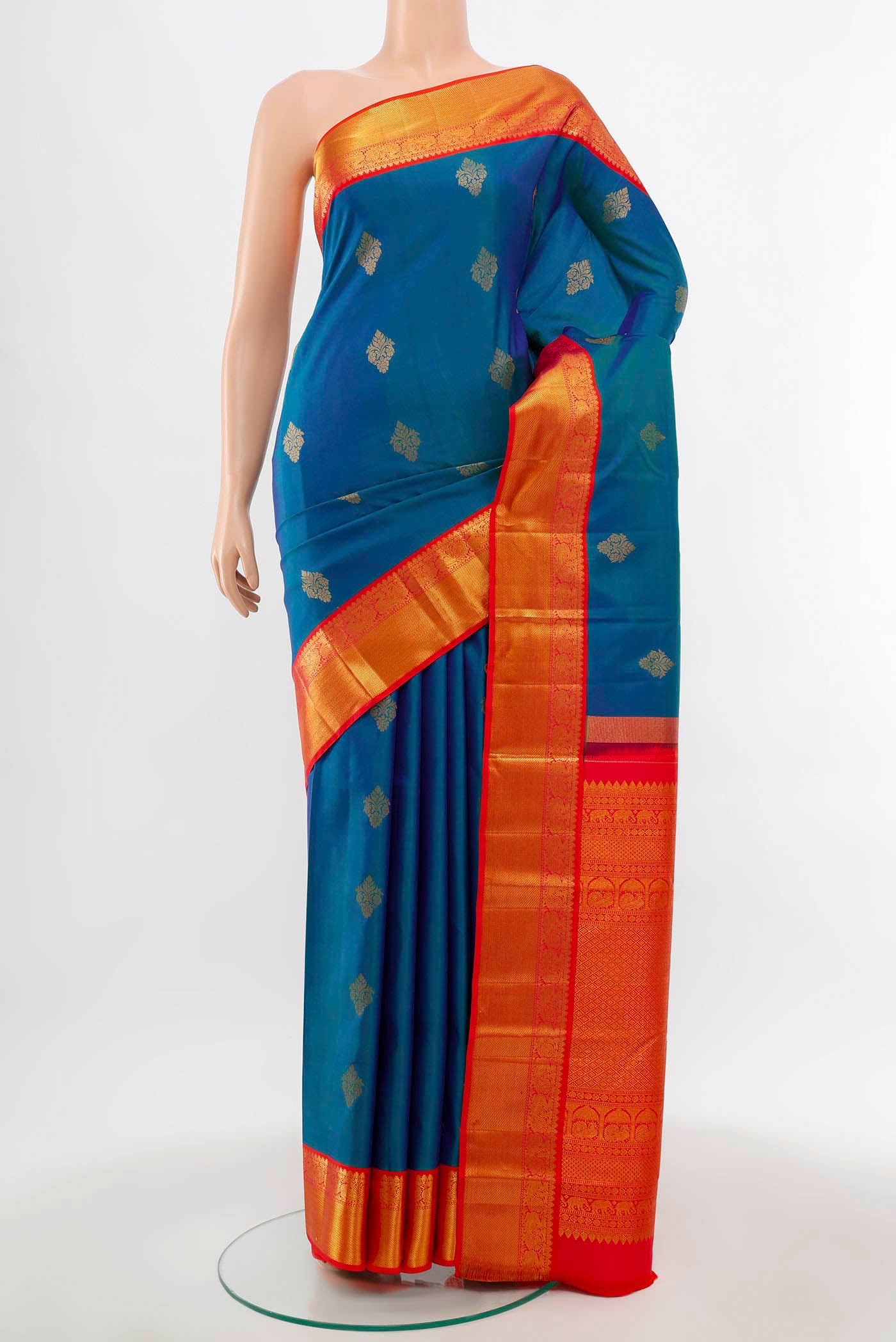 Peacock Blue Kanchipuram Silk Saree with Zari Butta on the body and Silk Border.  displayed on a mannequin