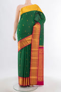 Bottle Green Kanchipuram Silk Saree with Zari Butta on the body and Silk Border.  displayed on a mannequin