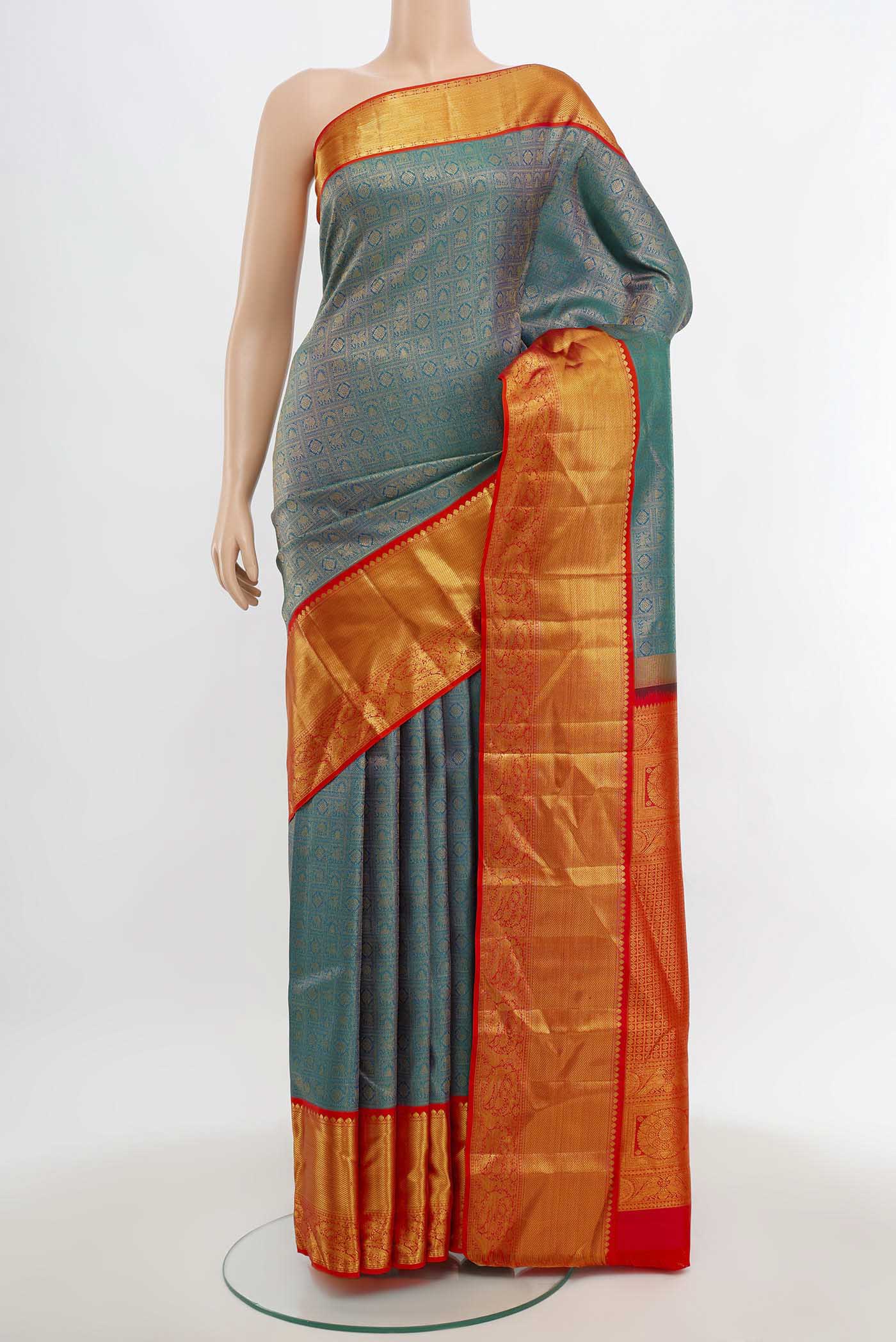 Peacock Blue Kanjivaram Silk Saree with Zari Butta on the body and Silk Border.  displayed on a mannequin