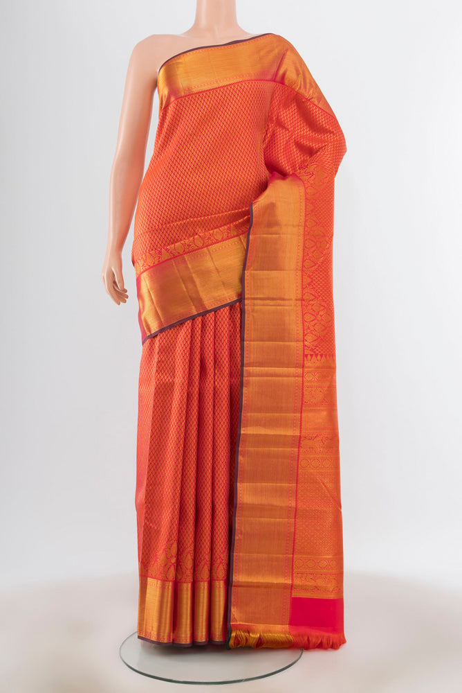 Peach Kanjivaram Silk Saree with Zari Butta on the body and Silk Border.  displayed on a mannequin
