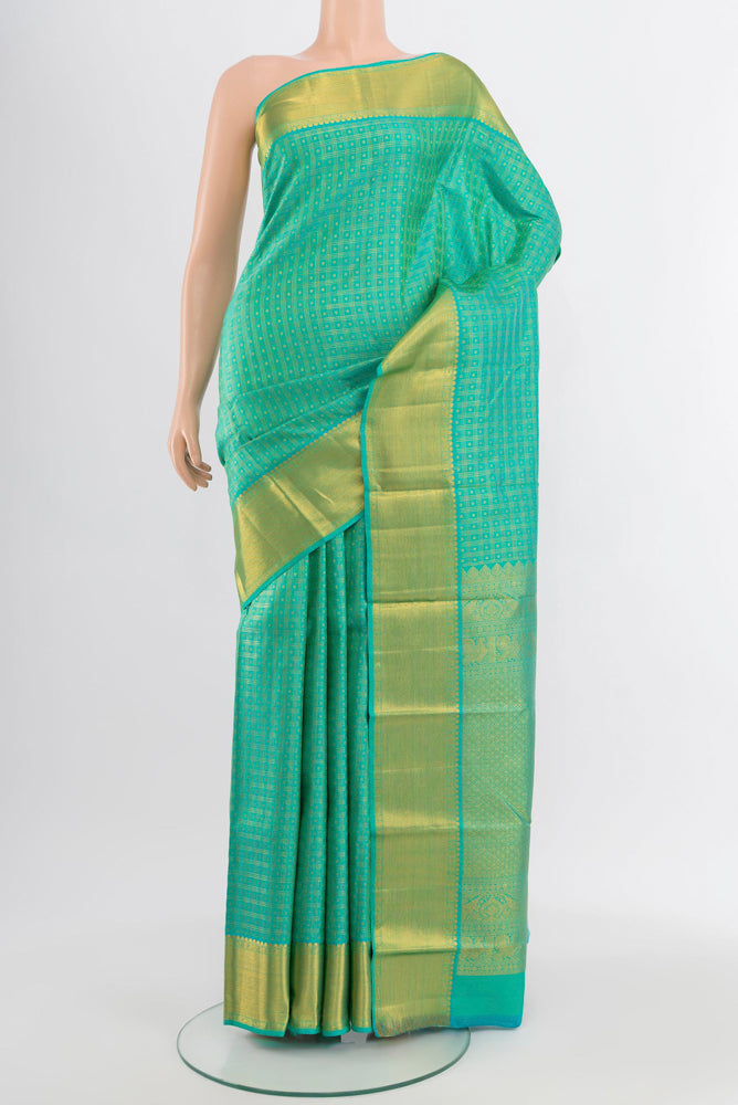 Light Green Kanjivaram Silk Saree with Zari Butta on the body and Silk Border.  displayed on a mannequin
