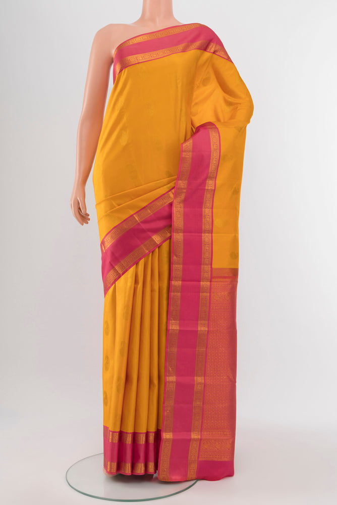 Yellow Kanchipuram Silk Saree with Zari Butta on the body and Silk Border.  displayed on a mannequin