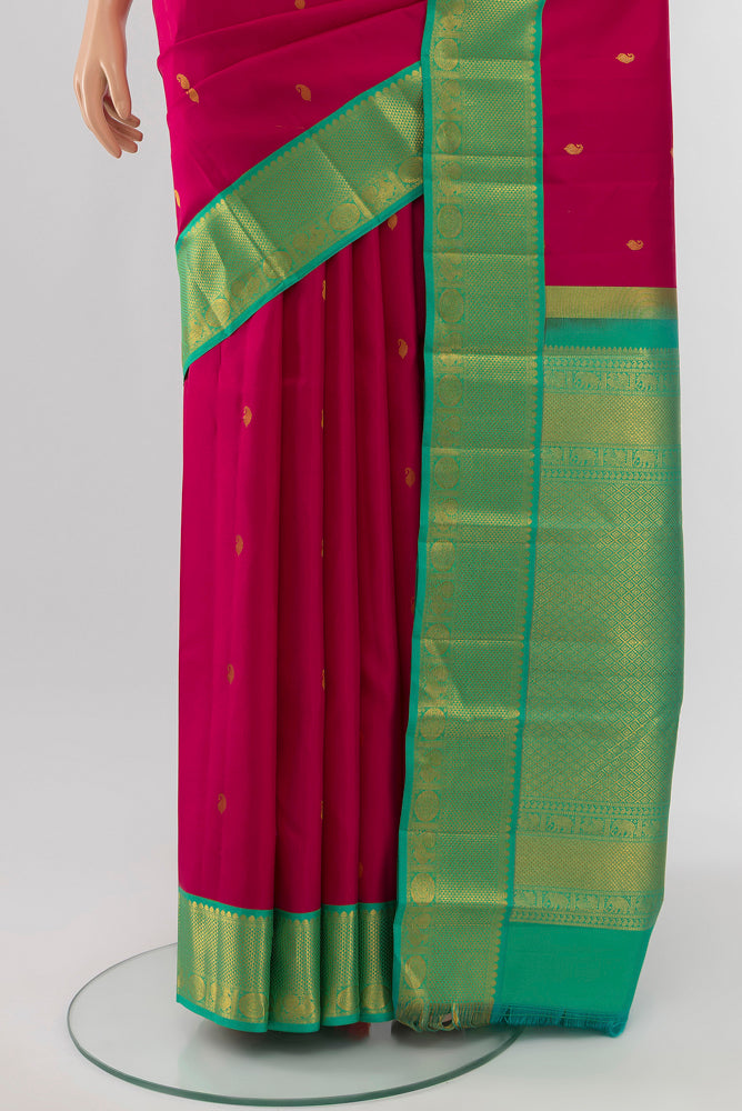 Pleats and pallu of Rani Pink Kanchipuram Silk Saree with Zari Butta on the body and Silk Border. 