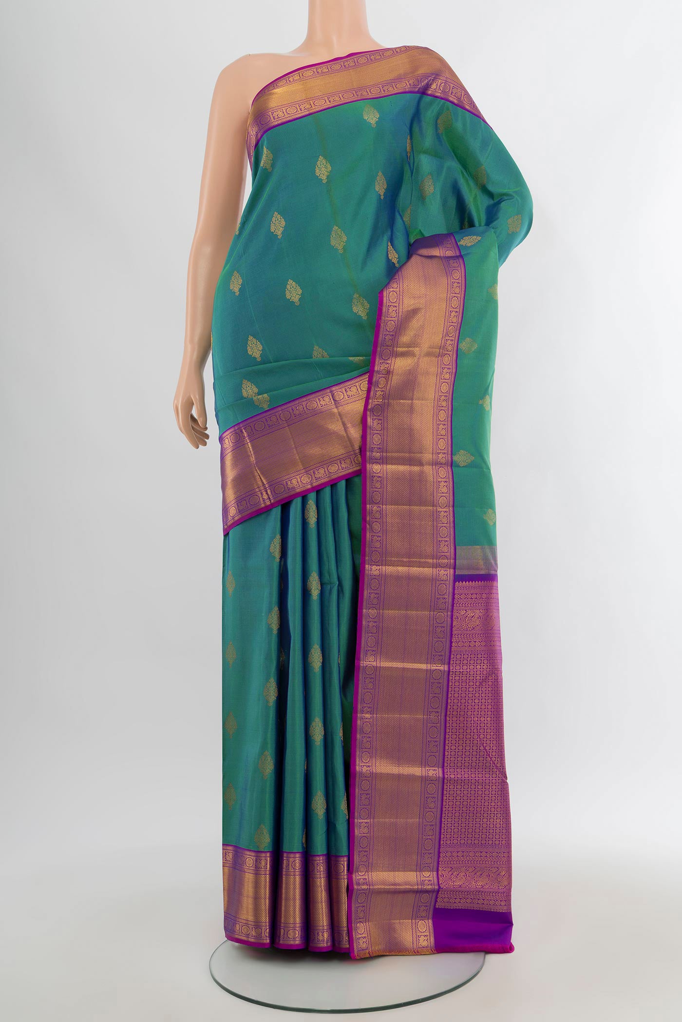 Peacock Blue Kanchipuram Silk Saree with Zari Butta on the body and Zari Border.  displayed on a mannequin